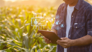 Man standing on a field with an ipad controlling ecological conditions for smart agriculture.