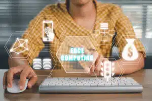 Edge AI computing concept, Person using computer on office desk with Edge computing icon on virtual screen, modern IT technology, internet and networking concept.